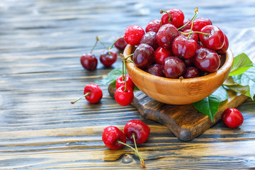 Ripe sweet cherry in a wooden bowl.