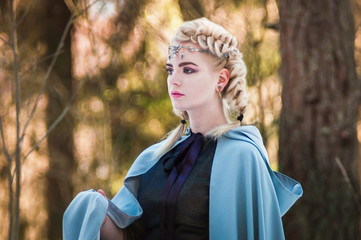 Fantasy elf girl in spring in a sunny forest