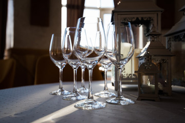 Empty glasses arranged on a table in the restaurant, cafe, or bar. Preparation for the birthday, wedding, or any celebration day.