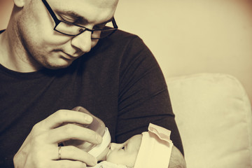 Father feeding from bottle newborn baby