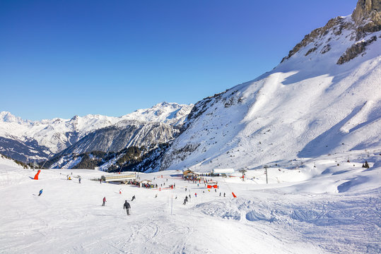 Skiers and snowboarders on the slopes in Courchevel winter resort, France.