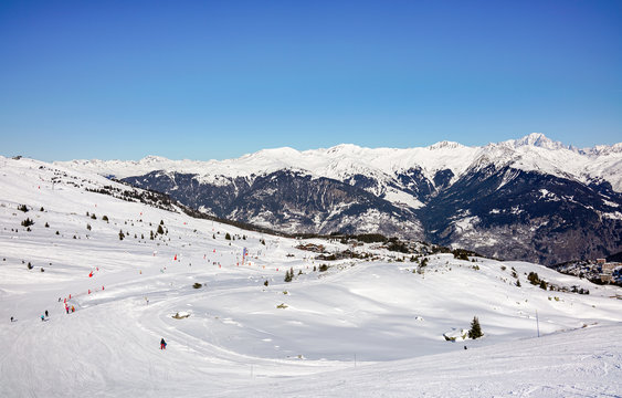 Skiers and snowboarders on the slopes in Courchevel winter resort, France.