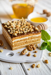 Delicious layered honey cake with chocolate and walnut topping