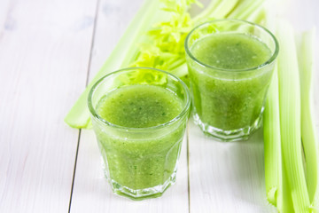 Vegetable cocktail made from celery leaves, healthy lifestyle on a white wooden background.