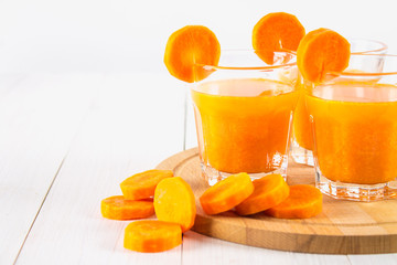 Fresh carrot juice on a wooden background