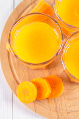 Fresh carrot juice on a wooden background