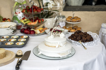Beautiful wedding cake with cream With text Love on top white flowers roses