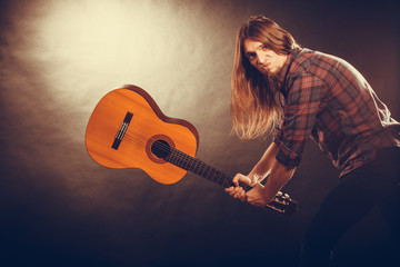 Rock musician destroys his guitar.