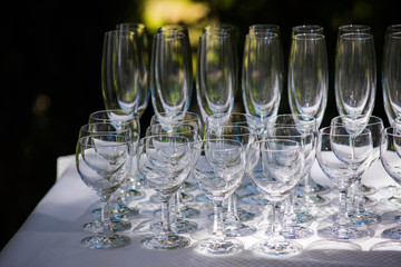 Empty glasses arranged on a table in the restaurant, cafe, or bar. Preparation for the birthday, wedding, or any celebration day.