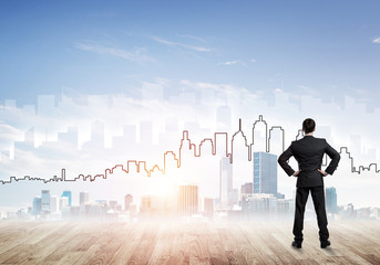 Motivation and inspiration concept with modern cityscape and businessman observing it