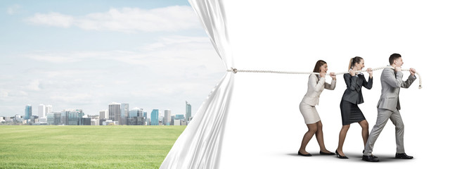 Obraz premium Young businesspeople working in collaboration and pulling white advertisement banner