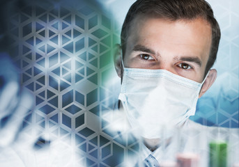 Young scientist mixing reagents in glass flask in clinical laboratory