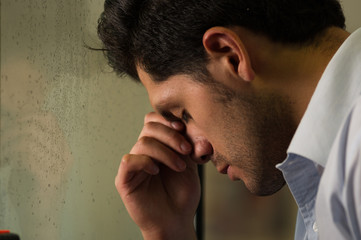 Obraz premium Worry and exhausted young man is depresed, gray background