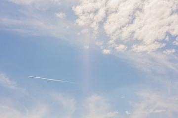 Jet smoke and blue sky with white clouds. Jet aircraft exhaust trail in sky.  