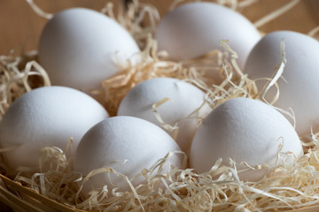 Fresh white eggs in a wicker basket