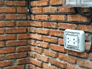 Outdoor white Electrical Outlet on brick wall with copy space.
