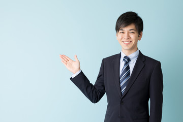 portrait of asian businessman indicating isolated on blue background