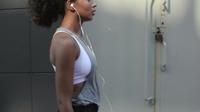 Side view of woman walking on street after workout