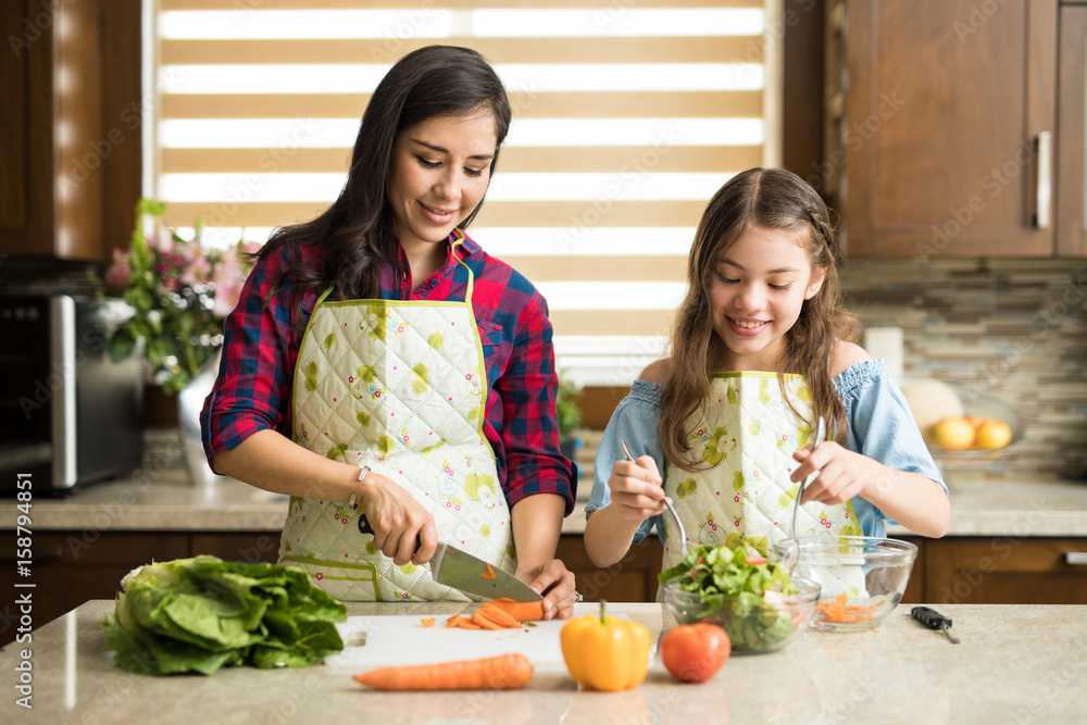 Wall mural Cute family making a salad at home