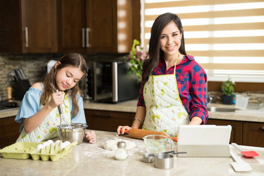 Latin mother cooking with her daughter