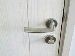 Door handle with lock on the white door, closeup. Concept of interior design modern room.