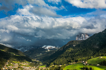 Looking towards the stunning Alpine mountain of Ortisei with blue sky and white clouds, an awesome view of the beautiful Dolomites can be seen in the distance, Northern Italy, Europe