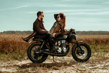 Obraz na płótnie Canvas Couple and cafe racer motorcycle