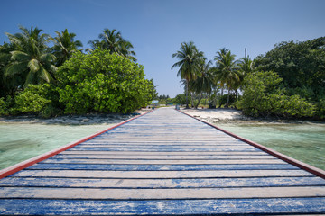 Tropical travel destinations with Maldives island and wooden wharf