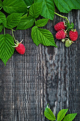 Old wooden board decorated raspberry and leaves