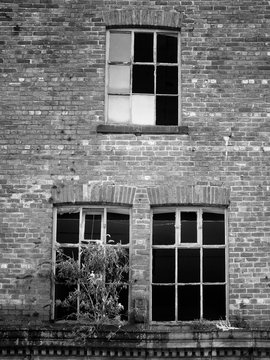 broken windows in a derelict abandoned brick building