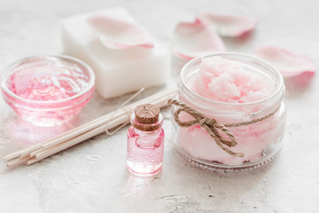 Obraz na płótnie Canvas cosmetic set with rose blossom and body cream on white desk background