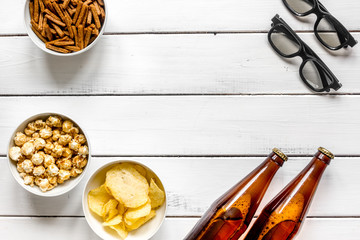 cinema and TV whatching with beer, crumbs, chips and pop corn white wooden background top view mock-up