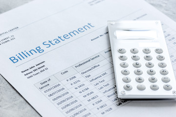 calculator, billing statement for doctor's work in medical center stone background