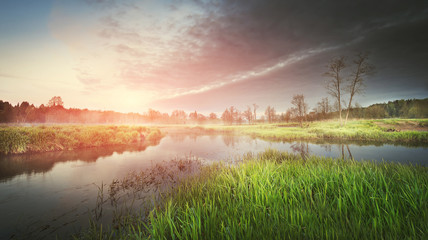 A landscape of nature on a summer morning on the river at sunrise