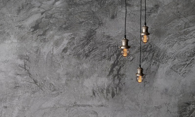 Industrial pendant lamps against a rough concrete wall. The interior of the loft style. Edison...