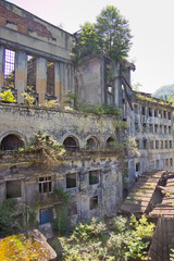 Obraz premium Abandoned overgrown ruins of destroyed by war Tkvarcheli (Tquarhcal) power plant, Abkhazia, Georgia