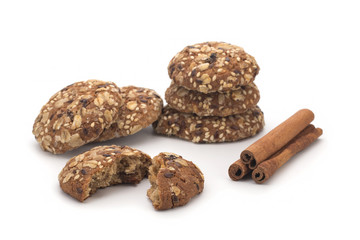 Oatmeal cookies and cinnamon sticks on white background