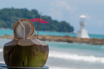 Fresh coconut drink with lighthouse in the background