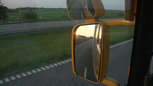 Driving truck on highway, close-up of side view mirror