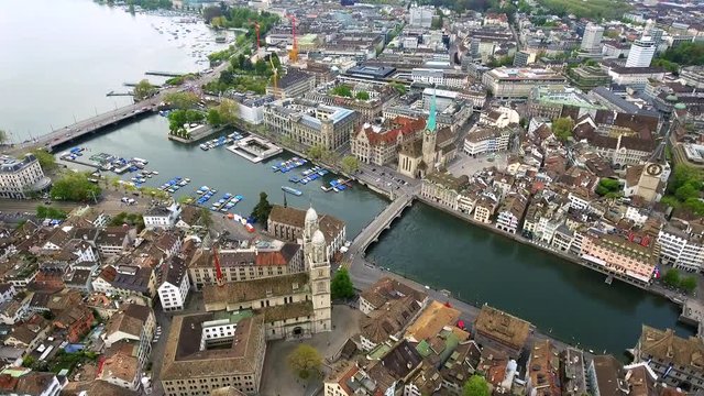 Helicopter View Aerial Video of Zurich Landmarks in City Center Town Hall Fraum&uuml;nster Church, Iconic Romanesque cathedral : Grossm&uuml;nster, Historic Gothic Church with a Large Clock Tower : St. Peter 4K