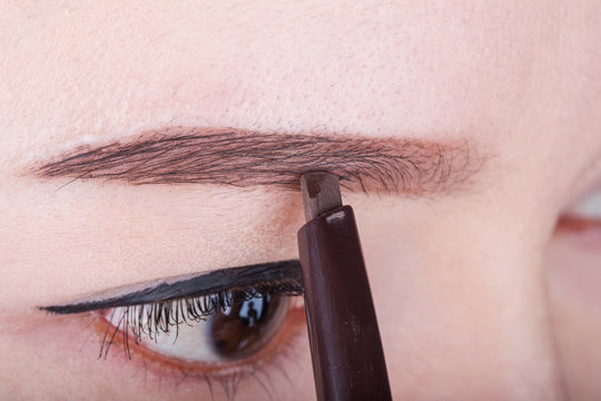 Woman Using Pencil Makeup Eyebrow