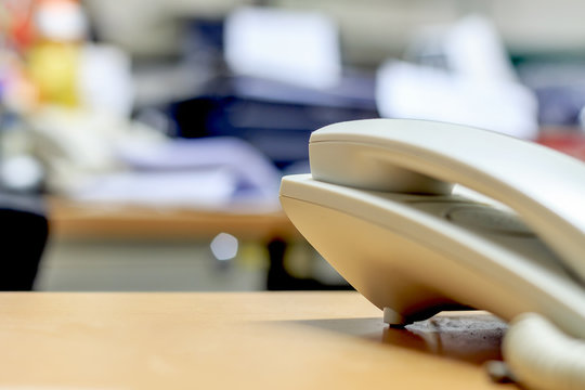 The phone is placed on the desk in office. soft-focus and over light