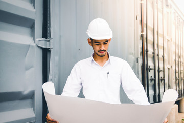 Civil engineer holding blueprint at the construction site.