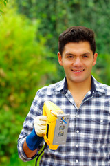 Close up of a man wearing job gloves working wood with electric jigsaw