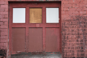 Boarded up window and red wall