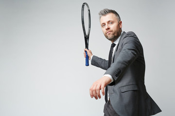 Waist up portrait of handsome middle aged man in business suit looking at camera while countering...