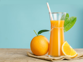 Glass of fresh orange juice on wooden table, Fresh fruits Orange juice in glass with group of orange on blue background, Selective focus on glass