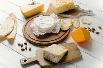 Cheese with almonds on a wooden board.