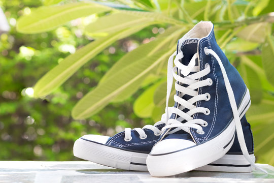 Pair of new blue sneakers on table top perspective and naturel background