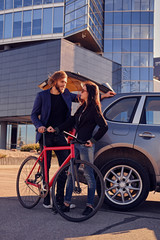 Urban couple with single speed bicycle near the car.